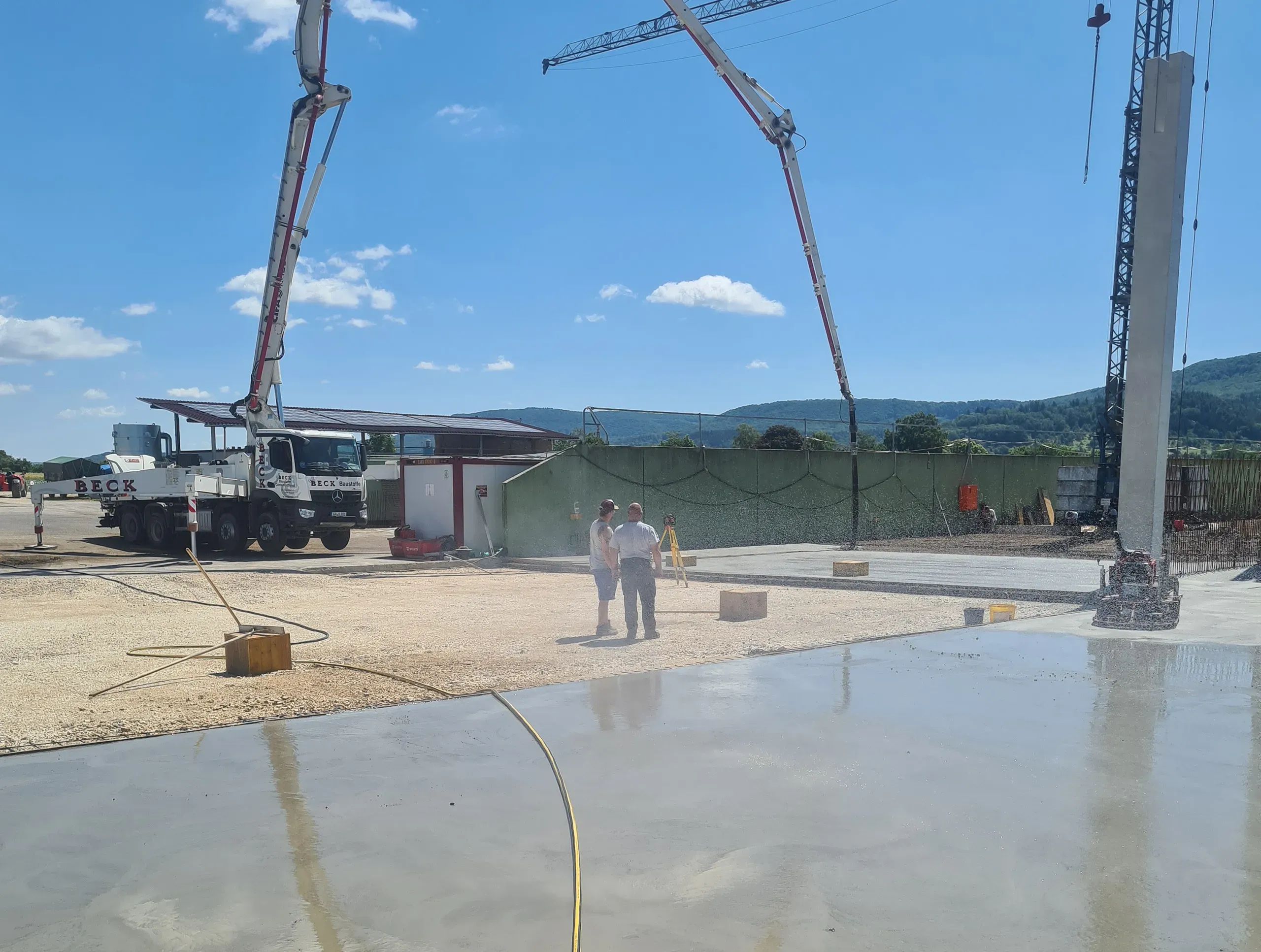 LKWs mit Betonpumpen, die einen glatten Betonboden auf einer Außenfläche gießen 